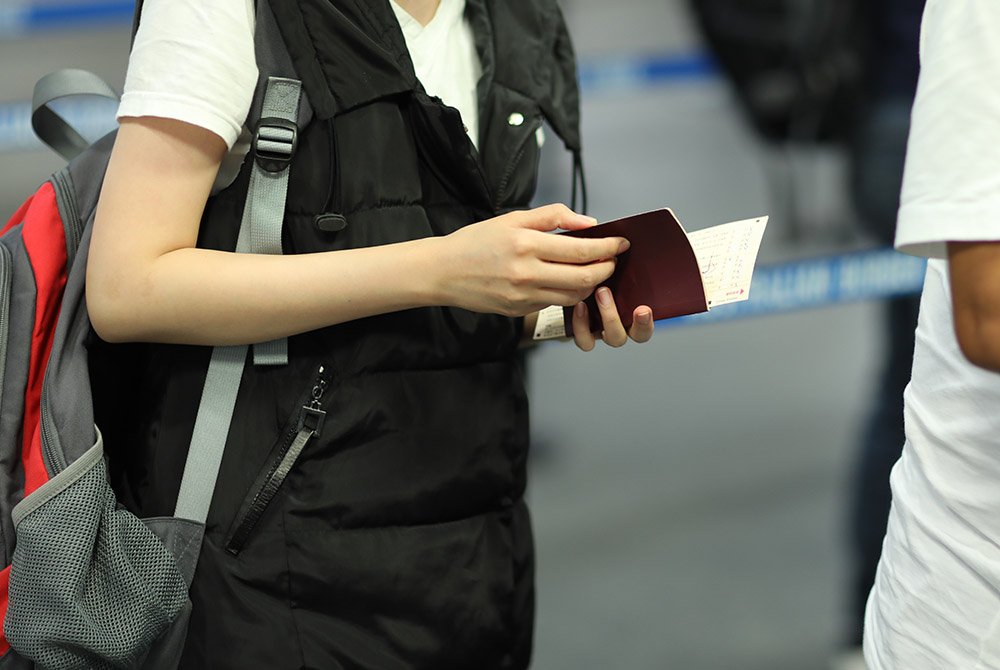 Person checking their passport and phone